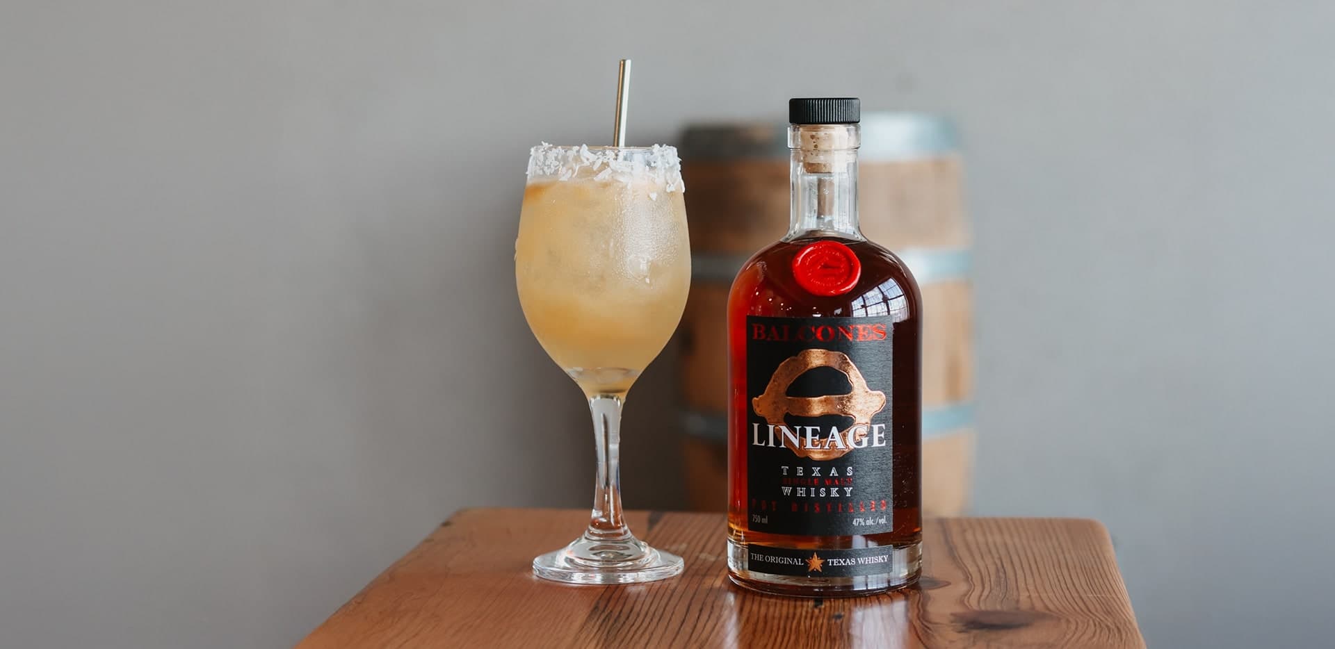 Bottle of Lineage Texas Single Malt Whisky with two glasses of Balcola cocktails
