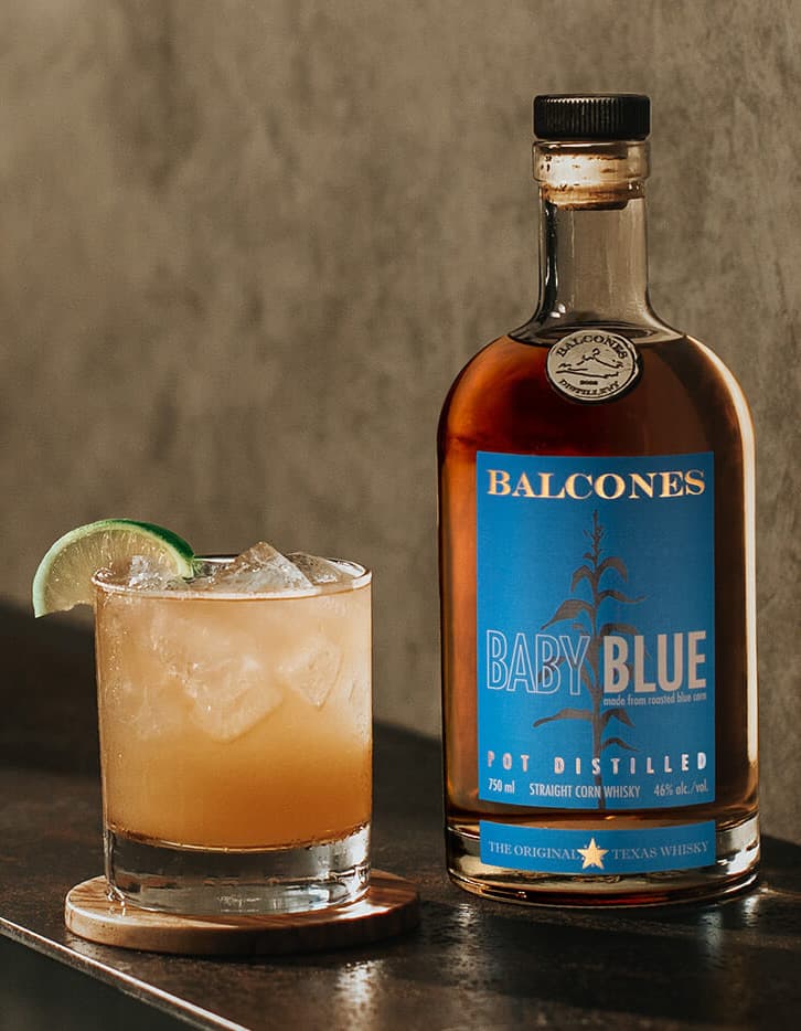 Bottle of Texas 1 Single Malt Whisky with Imposterita Cocktail on Table