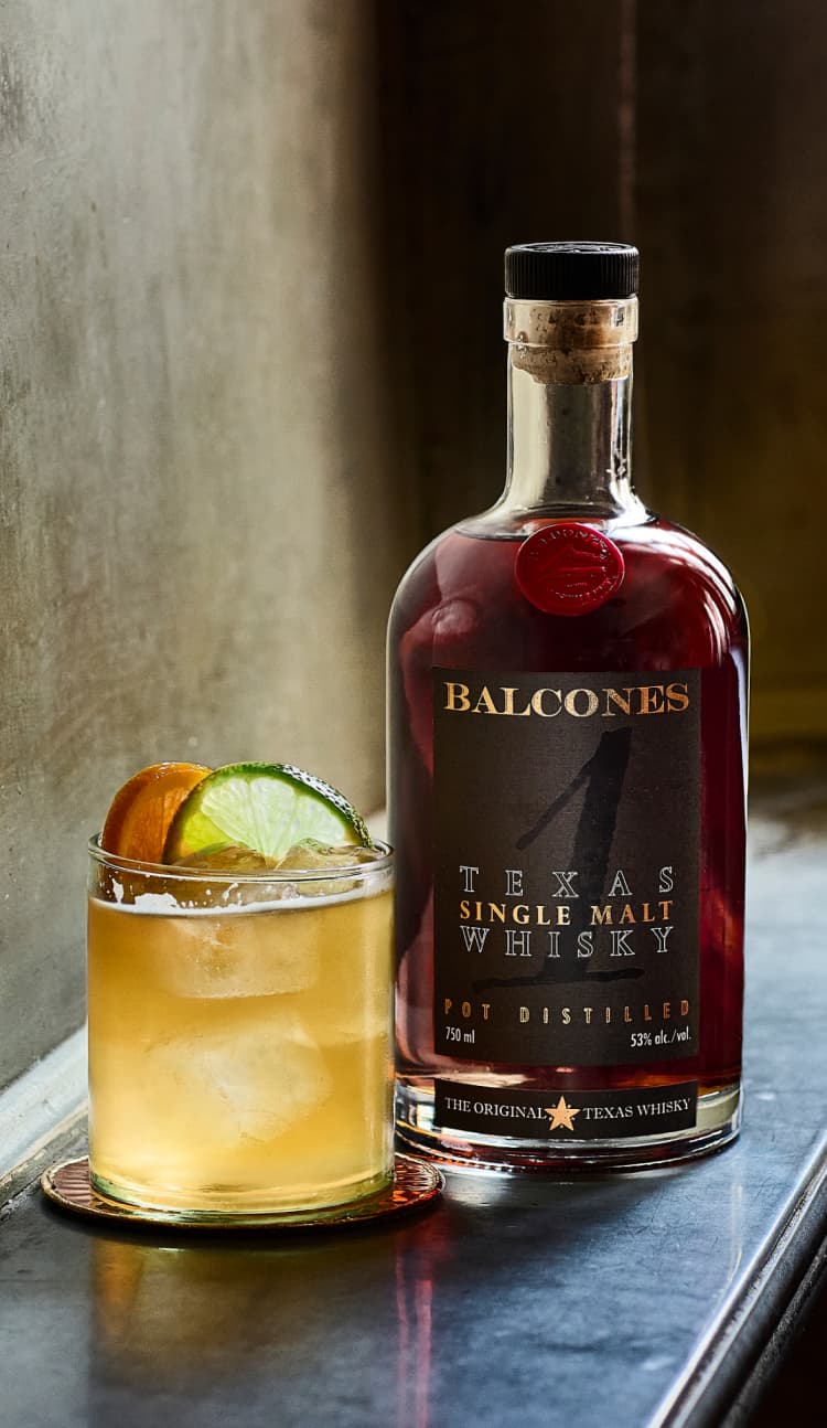 Bottle of Texas 1 Single Malt Whisky with Imposterita Cocktail on Table