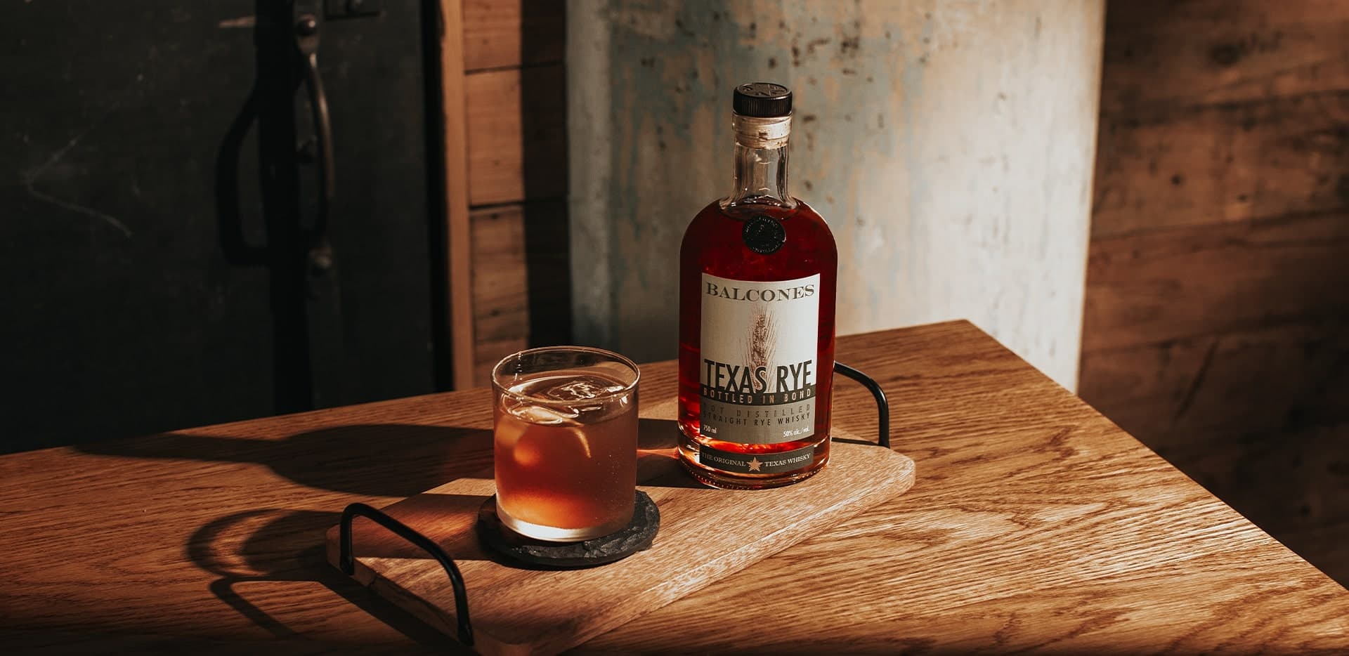 Bottle of Lineage Texas Single Malt Whisky with two glasses of Balcola cocktails