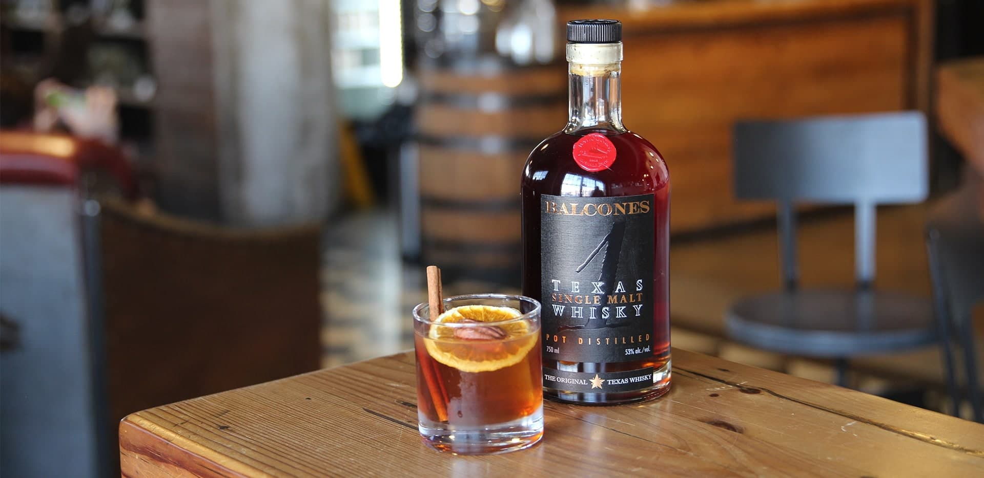 Bottle of Lineage Texas Single Malt Whisky with two glasses of Balcola cocktails