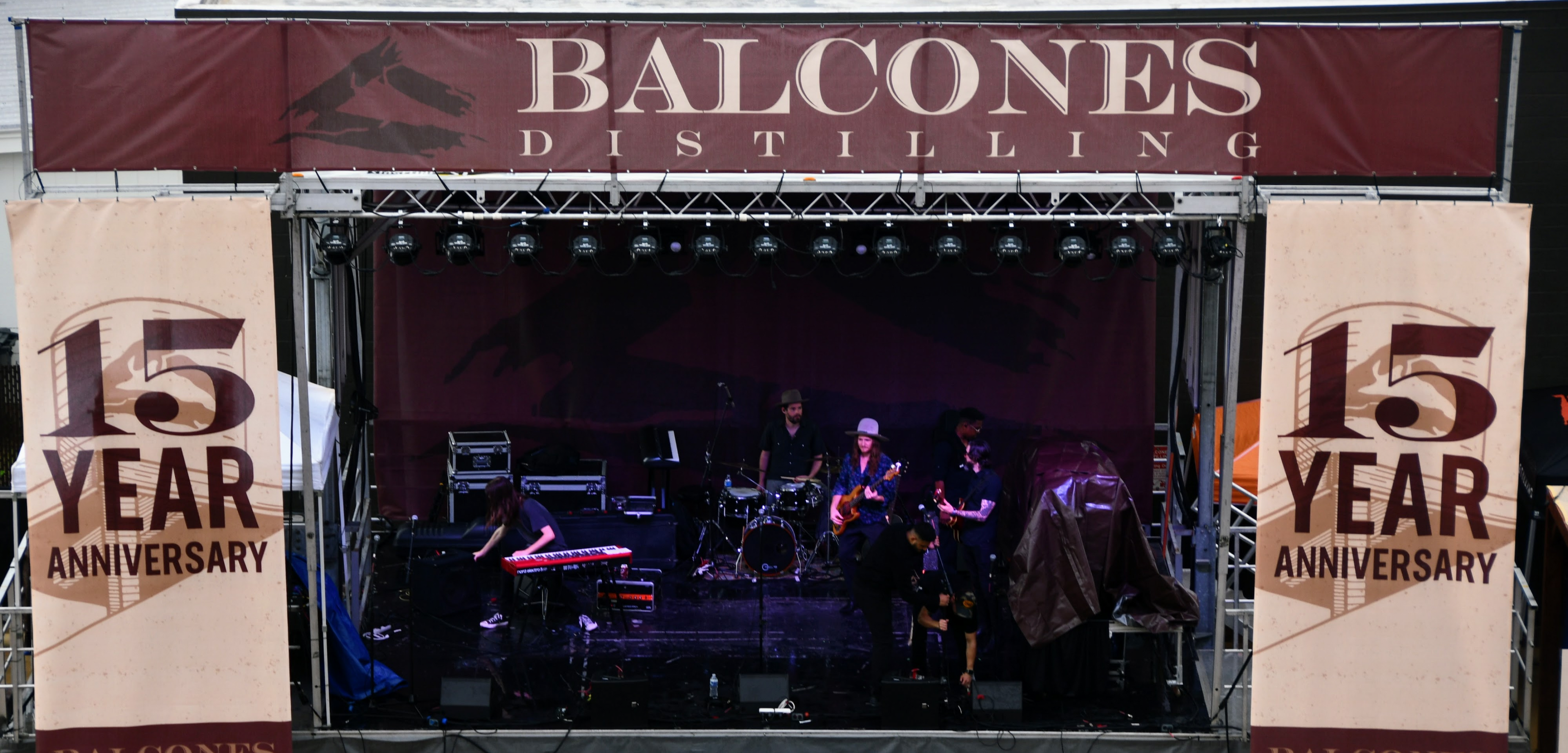 Band performing with 15 Year Anniversary posters surrounding stage