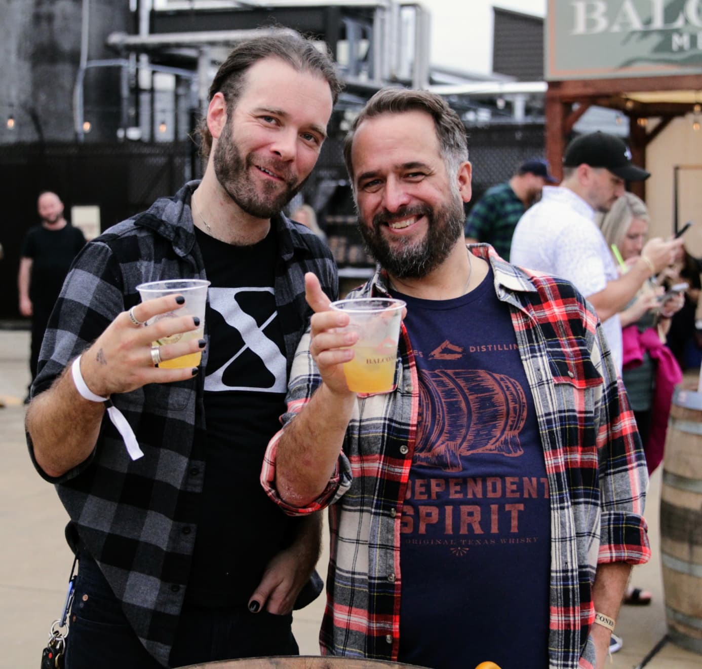 Two men holding cocktails and smiling