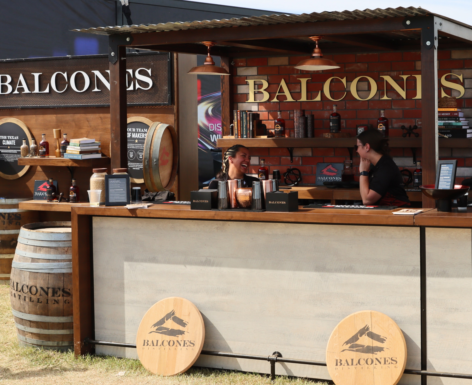 Two bartenders chatting behind Balcones' bar