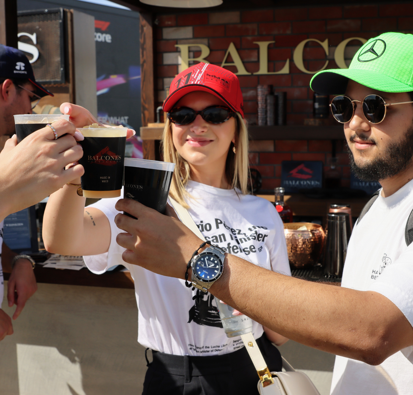 Three people cheers'ing with Balcones' cocktails