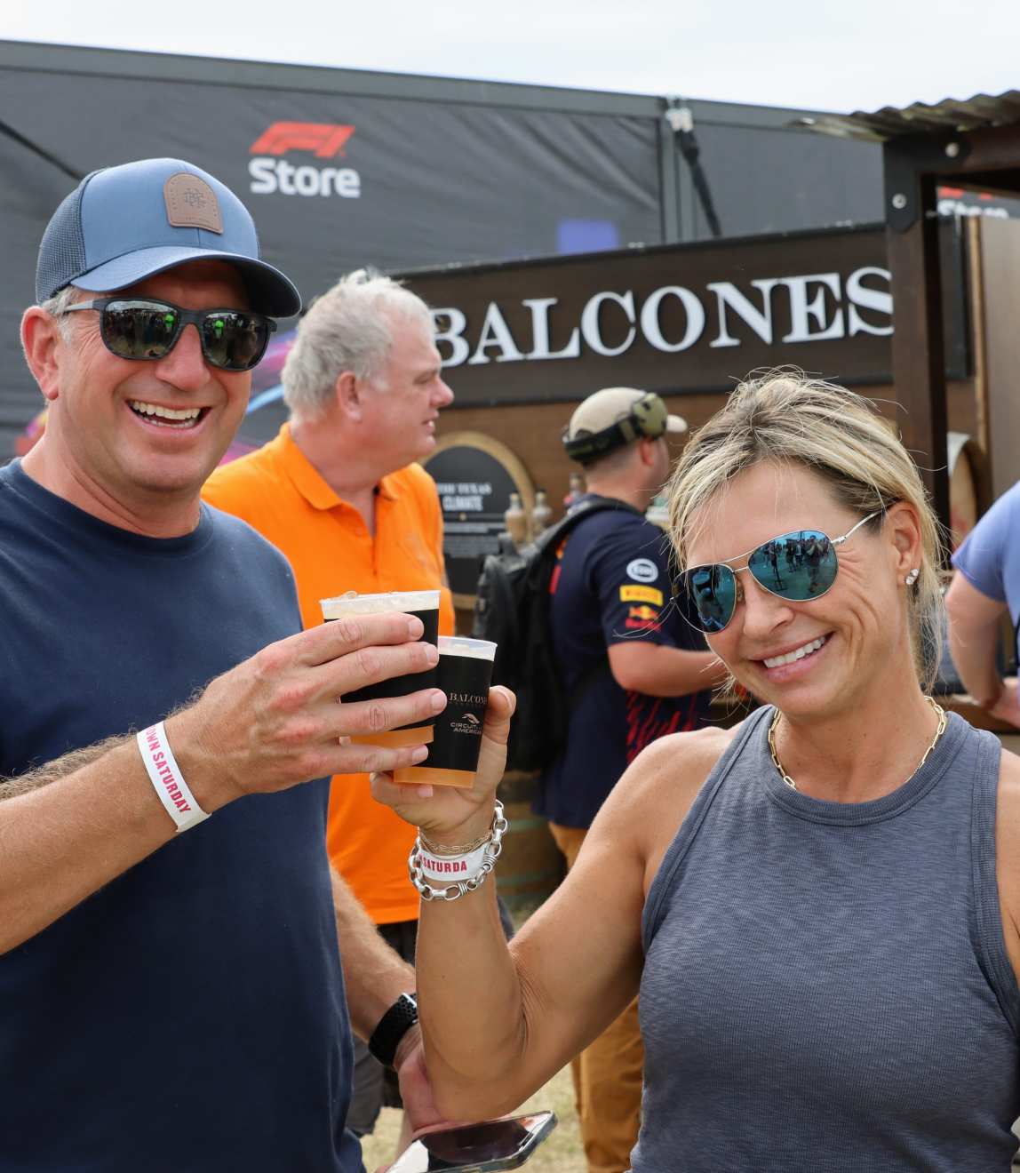 Two people cheers'ing and smiling with Balcones' cocktail
