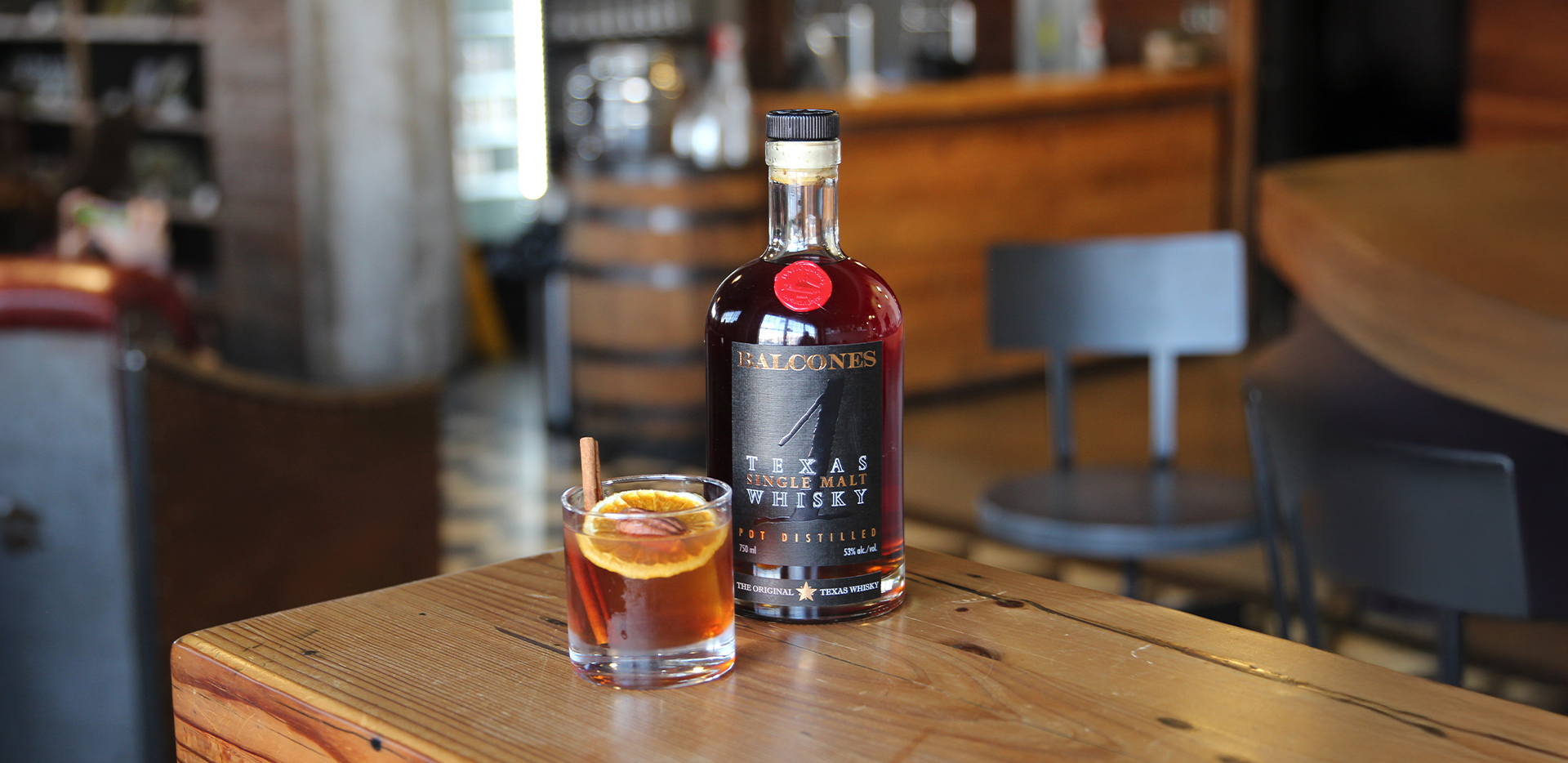 Bottle of Lineage Texas Single Malt Whisky with two glasses of Balcola cocktails