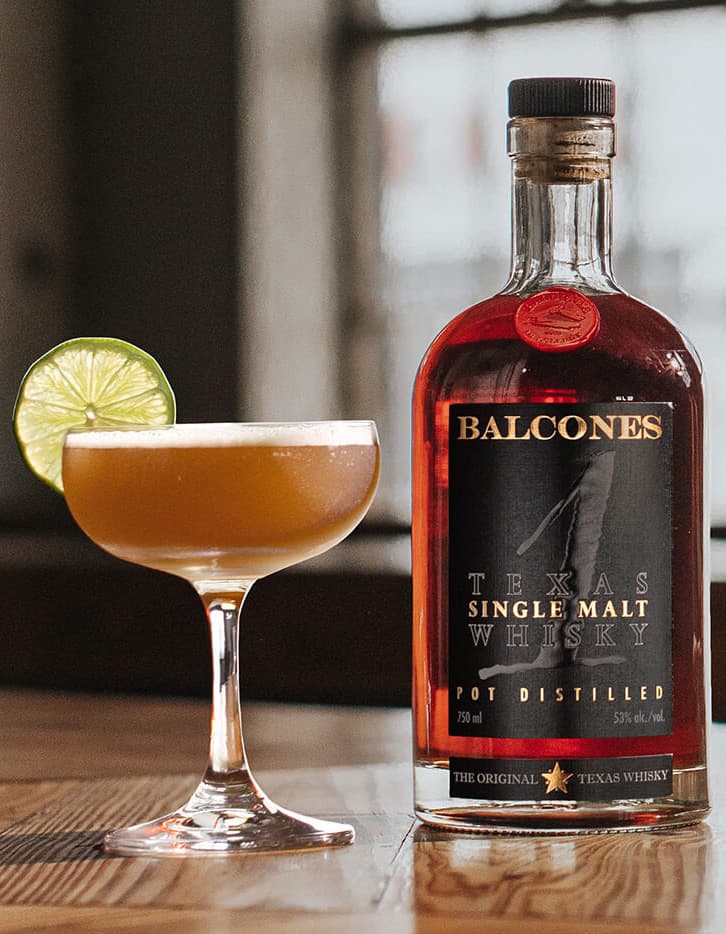 A bottle of Texas 1 Single Malt Whisky with next to a The 1 Daiquiri cocktail.